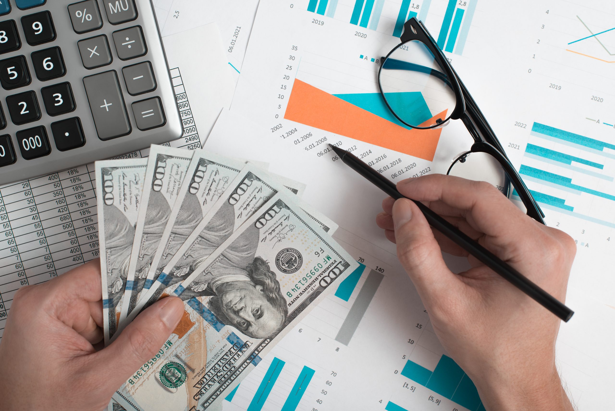 Business, finance and accounting. Close-up of an office worker's hand holding money and analyzing economic indicators, reports, graphs at workplace Як залучити інвестиції у стартап: стадії та документи Окрім того, потрібно придумати свій стартап, унікальну ідею, а це не просто саме по собі, так ще й потрібно знайти гроші для запуску та реалізації проекту.